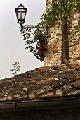 Ausragende Laterne an Hausecke und Blick auf altes Ziegeldach