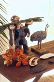 Tierfiguren aus Holz und tropische Früchte auf einer Holzbank