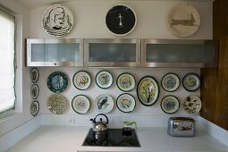 Kitchen counter with floating wall cabinets and a collection of plates