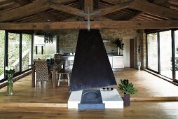 Open fireplace in the living room of a renovated country home with a raised dining area