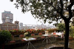 Feiern auf der Dachterrasse - Tische und Stühle auf regennassem Boden