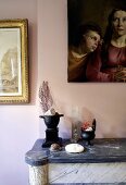 Still life - decorative objects on a stone mantelpiece in front of a pink wall