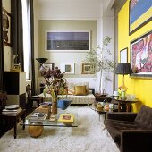 Hoher Wohnraum möbliert im siebziger Jahre Stil mit Flokatiteppich und braunem Sessel vor gelber Wand