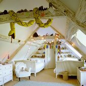 A child's attic room with rustic wood beams equipped with white furniture