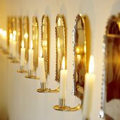 A romantic atmosphere - burning candles in brass-coloured wall holders