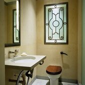 Designerwaschtisch mit Spiegel und Toilette im renovierten Bad