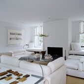 A designer living room with a fireplace and white upholstered furniture