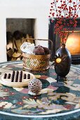 A board game, flowers in a vase and a knitting basket on a stone table with a floral pattern