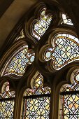 A colourful stained glass window in a Gothic pointed arch