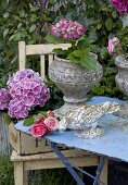 Garden flowers in antique stone containers and stone figurine