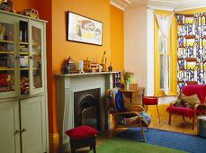 Green cupboard next to fireplace in yellow sitting room