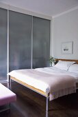 Doppelbett im Designer Schlafzimmer mit Einbauschrank und Glasschiebetüren