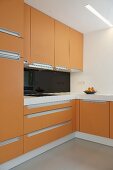 Moderne Küchenecke mit orangefarbenen Fronten