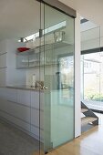 View through glass screen to modern galley kitchen