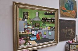Moderne Küche mit Stilmixmöbeln und grüner Wand reflektiert im Spiegel