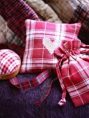 A detail of a red check fabric bag, pin cushion, pillow