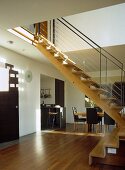 Holztreppe mit Metallgeländer im offenen Wohnraum mit Essbereich