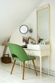 50s style green chair in front of a dressing table with mirror