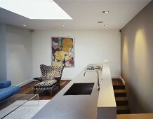 Offener Wohnraum mit Designer Küchenblock und Sessel im Retrolook