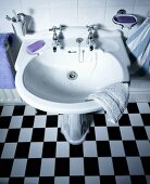 Waschbecken mit Armatur im Vintagelook und Boden mit Schachbrettmuster
