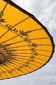 Gespannter Sonnenschirm in Gelb mit asiatischem Muster