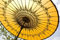 An open yellow sunshade with an oriental pattern