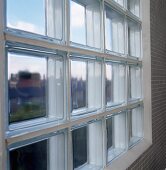 Glasbaustein-Fenster in Bad mit hellgrauen Mosaikfliesen