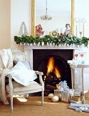 Weihnachtsschmuck auf brennendem Marmorkamin und weiße antike Möbel in traditionellem Wohnzimmer