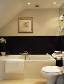 Modernes Bad im Dachgeschoss mit gerahmtem Bild über schwarzer Wandverkleidung