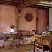Esszimmer in altem Fachwerkhaus mit in Wischtechnik rosa bemalten Wänden und einfachen Möbeln im Landhausstil