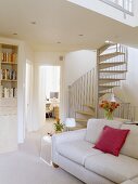 Weisses Sofa und Wendeltreppe im modernen weißen Wohnzimmer