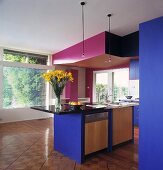 Ein Geschirrspüler und ein Spülbecken sind in einer Kochinsel eingebaut worden, die unter einer rosa Zwischendecke der modernen und blauen Küche mit Parkettboden steht