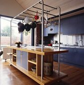 Eine Kücheninsel mit einer Stahlkonstruktion für Küchenutensilien, die aufgehängt werden können