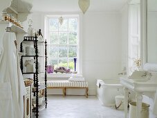 Ein großzügiges weißes Badezimmer, das mit einem antiken barley twist Regal ausgestattet ist