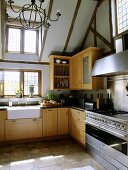 Eine moderne Landhausküche ist mit einem Edelstahl Ofen und einem weißen Spülbecken eingerichtet worden