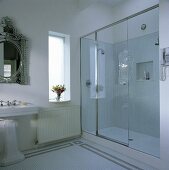 Ein modernes Badezimmer mit einem venezianischen Spiegel und einer separaten Dusche