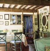 Blaugrüne Stühle und karierte Tischdecke auf Esstisch unter rustikaler Holzdecke im Landhaus