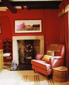 Gemusterter roter Sessel neben Kamin im traditionellen Wohnzimmer mit roten Wänden