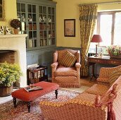 Gemusterte roten Sofagarnitur im Wohnzimmer mit hellgelben Wänden und grau-blauem Einbauschrank