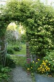 Geziegelter Torbogen mit Kletterrose im Garten