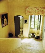 Schlichtes Treppenhaus mit Steintreppe und geöffneter Toilettentür
