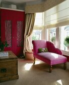 Chaiselongue mit rosa Stoffbezug im Erker mit Raffrollos vor Fenster