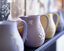 A collection of pastel-coloured ceramic jugs