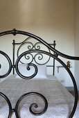 A bed with a wrought iron frame