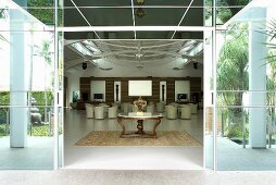 A view through an open sliding door into an elegant entrance hall with an 18th century table