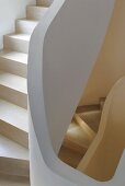 Winding staircase with wooden treads and stone railing