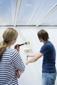 A couple painting a wall