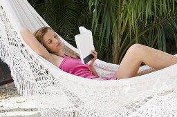 A woman in a hammock reading a book