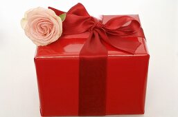 Rot verpacktes Geschenk mit Rose