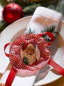 Gedeck mit Serviette und Weihnachtsmann-Oblate